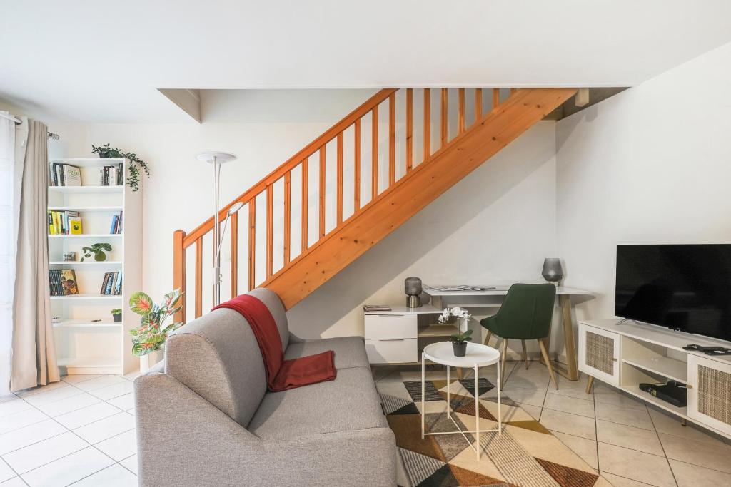 sala de estar con sofá y escalera en Chic apart duplex with parking, en Palaiseau