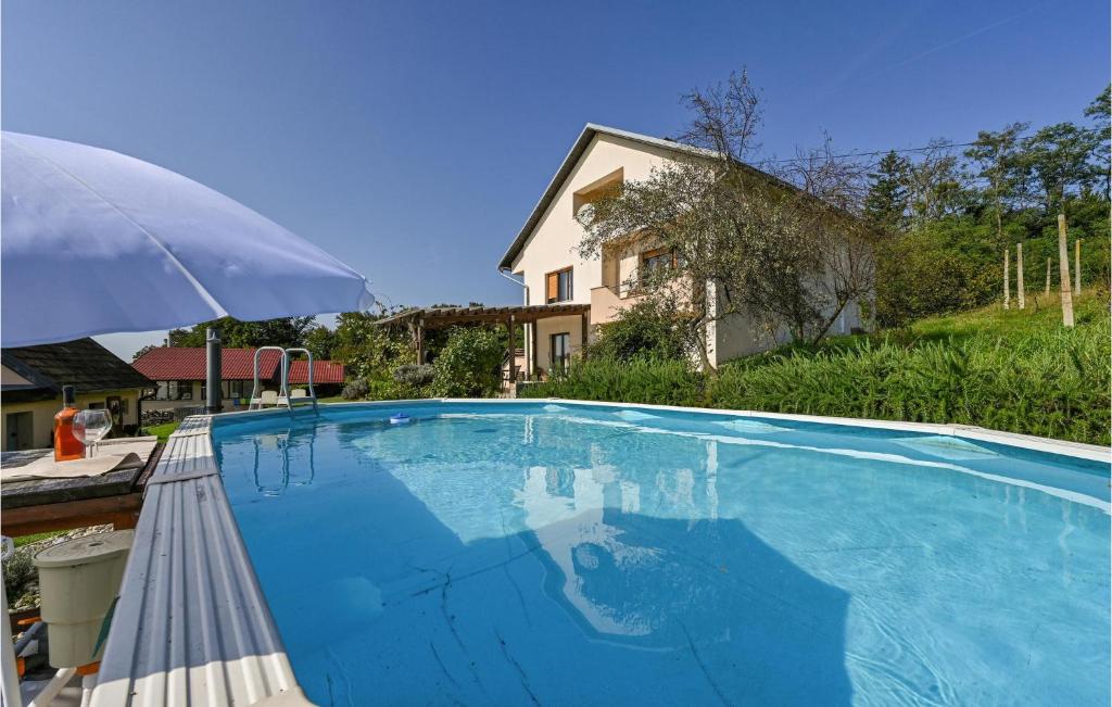 une grande piscine bleue avec un parasol dans l'établissement Nice Apartment In Grabrovnik With Sauna, à Grabrovnik