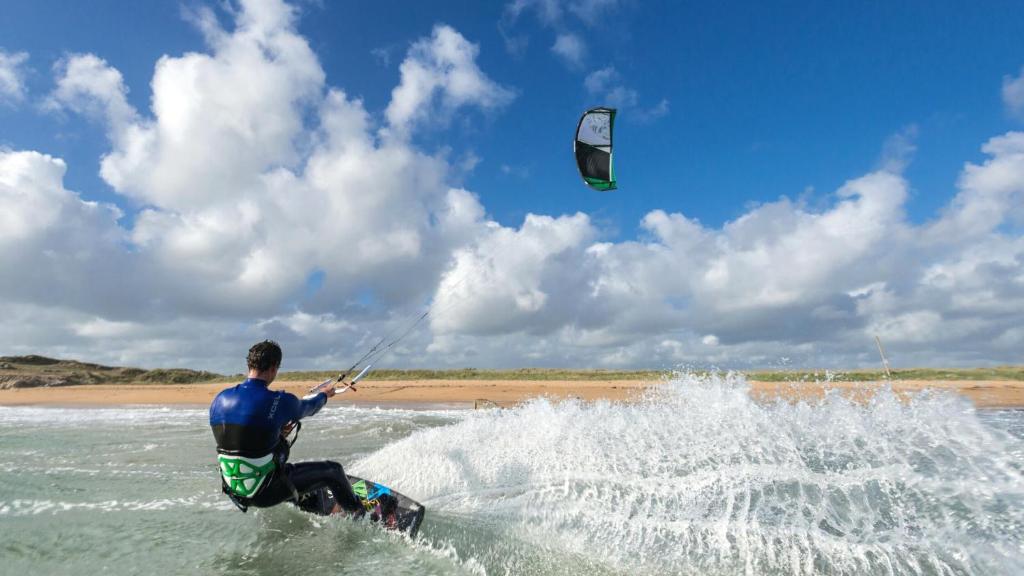 a man kite surfing in the ocean on the beach at Naéco Erdeven in Erdeven