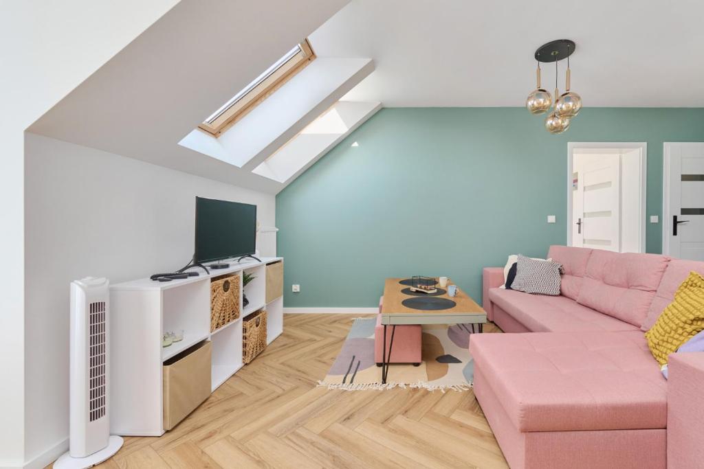 salon z różową kanapą i telewizorem w obiekcie Spacious Family Apartment with FREE GARAGE by Renters we Wrocławiu