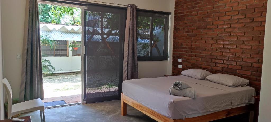 a bedroom with a bed and a brick wall at Casa Sixta in Puerto Escondido