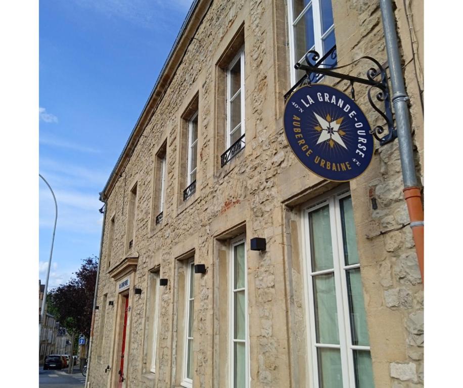 un bâtiment avec une horloge sur son côté dans l'établissement La Grande-Ourse, à Charleville-Mézières