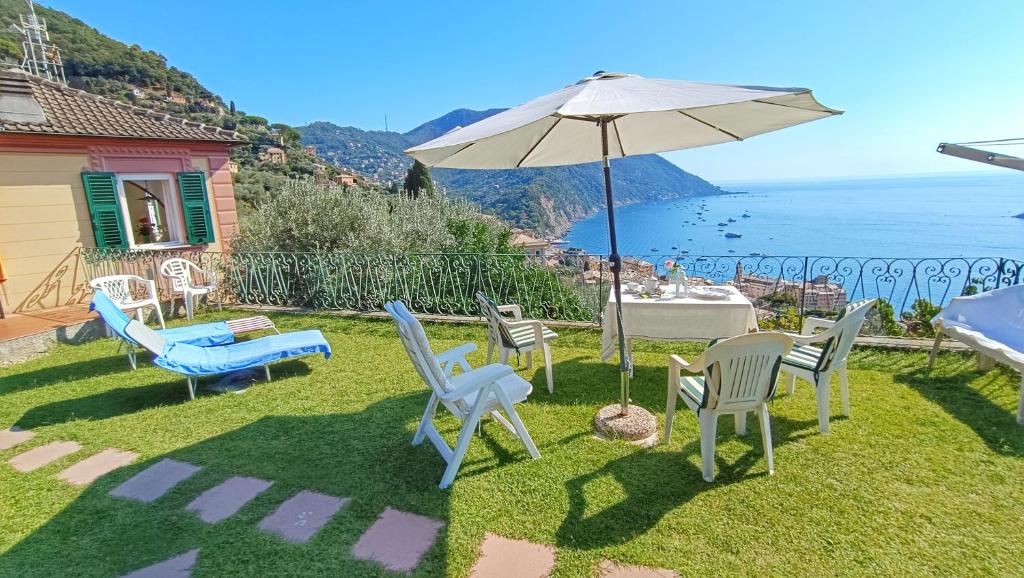 a patio with a table and chairs and an umbrella at Villa Mortola in Camogli
