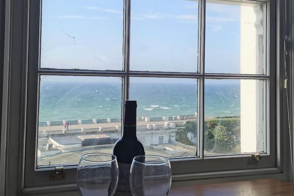 a bottle of wine and two glasses in front of a window at Relax and enjoy the sea view in Kent