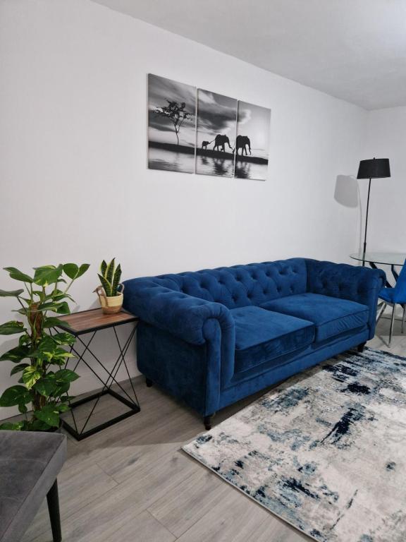 - un canapé bleu dans le salon dans l'établissement Stylish 2 bed home- short walk to Tottenham Stadium/Stations, à Londres