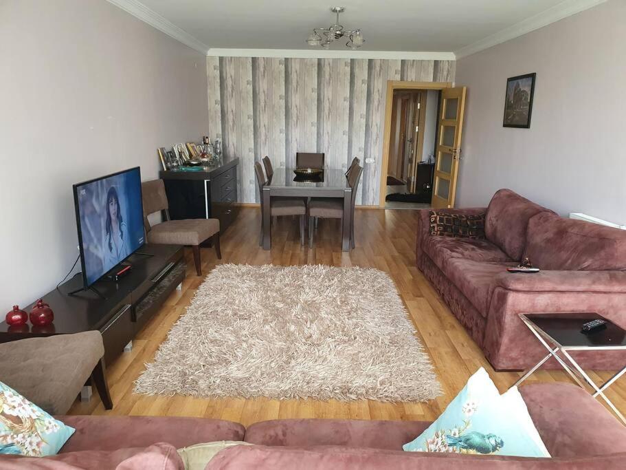 ein Wohnzimmer mit einem Sofa und einem Flachbild-TV in der Unterkunft Bostanlı Sahile Yakın 2+1 Daire in Karşıyaka