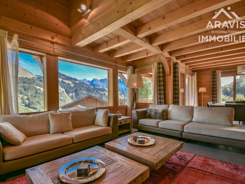 a living room with couches and a table and windows at Chalet Le Grand-Bornand, 5 pièces, 8 personnes - FR-1-391-8 in Le Grand-Bornand