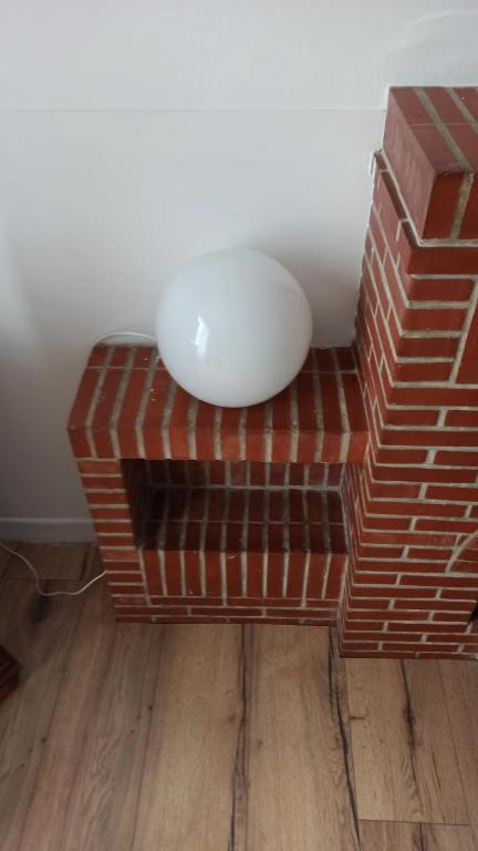 a white bowl sitting on top of a brick stool at Gîte les Pieds dans l&#39;eau bord de Sèvre, 10 min du Puy du Fo in Treize-Vents