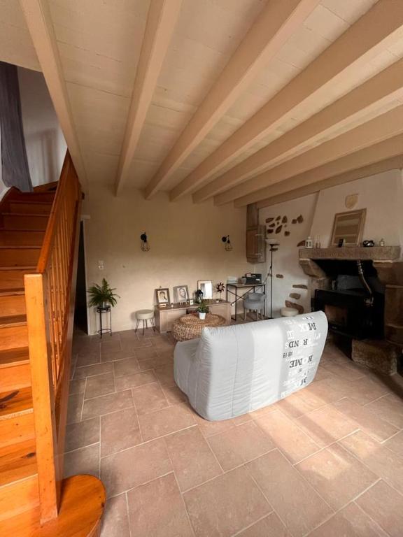 a living room with a couch and a piano at Gîte les Pieds dans l&#39;eau bord de Sèvre, 10 min du Puy du Fo in Treize-Vents