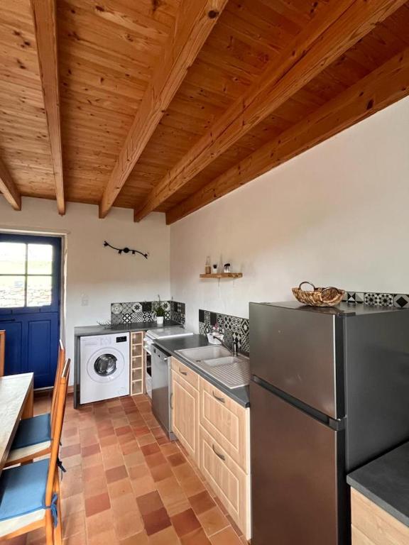 a kitchen with a refrigerator and a dishwasher at Gîte les Pieds dans l&#39;eau bord de Sèvre, 10 min du Puy du Fo in Treize-Vents