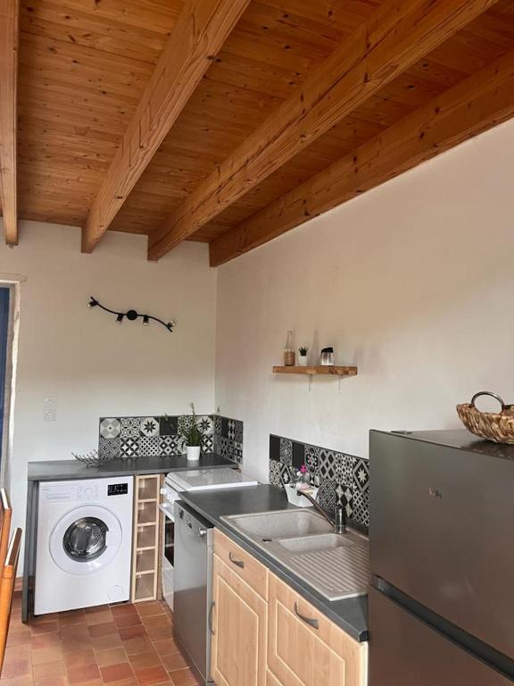 a kitchen with a sink and a dishwasher at Gîte les Pieds dans l&#39;eau bord de Sèvre, 10 min du Puy du Fo in Treize-Vents