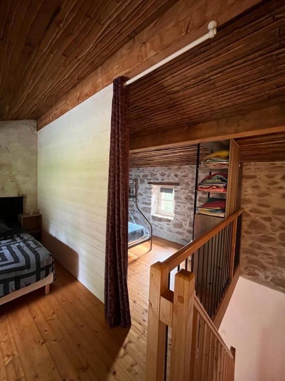 a room with a bed and a staircase in a house at Gîte les Pieds dans l&#39;eau bord de Sèvre, 10 min du Puy du Fo in Treize-Vents