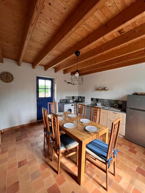 a dining room with a wooden table and chairs at Gîte les Pieds dans l&#39;eau bord de Sèvre, 10 min du Puy du Fo in Treize-Vents