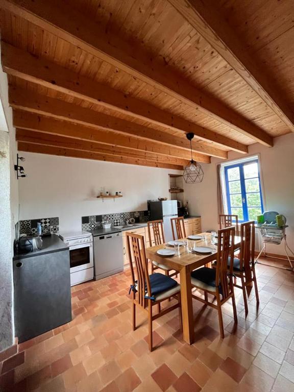 a dining room with a table and chairs in a kitchen at Gîte les Pieds dans l&#39;eau bord de Sèvre, 10 min du Puy du Fo in Treize-Vents