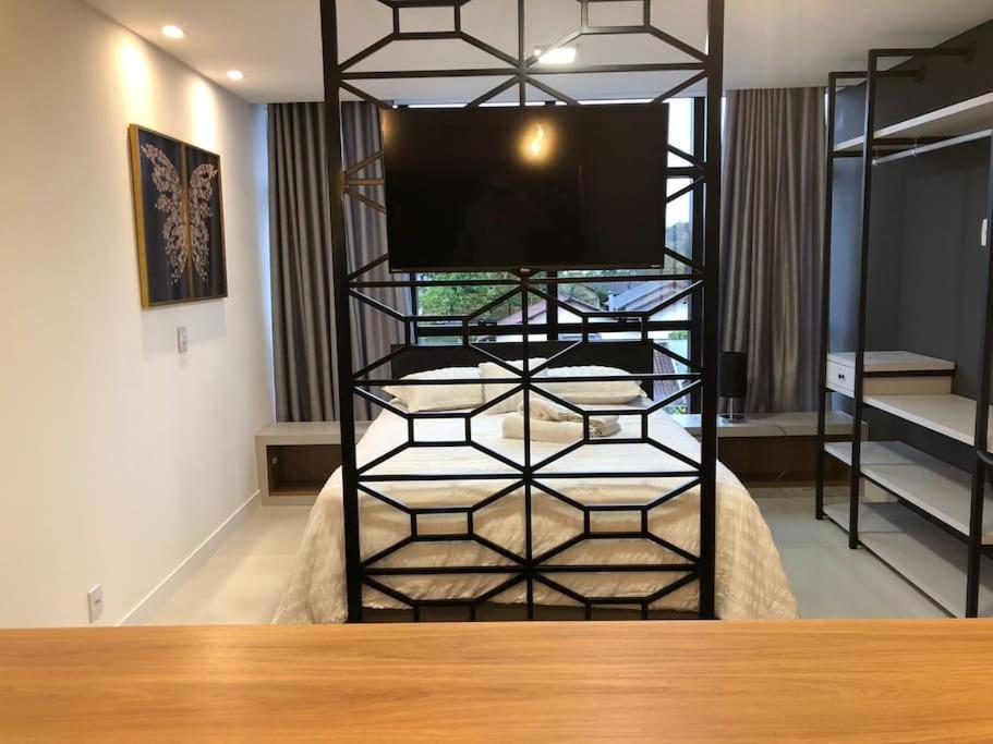 Habitación con cama y TV en la parte superior en Lindo Flat Central - Home Business en Pomerode