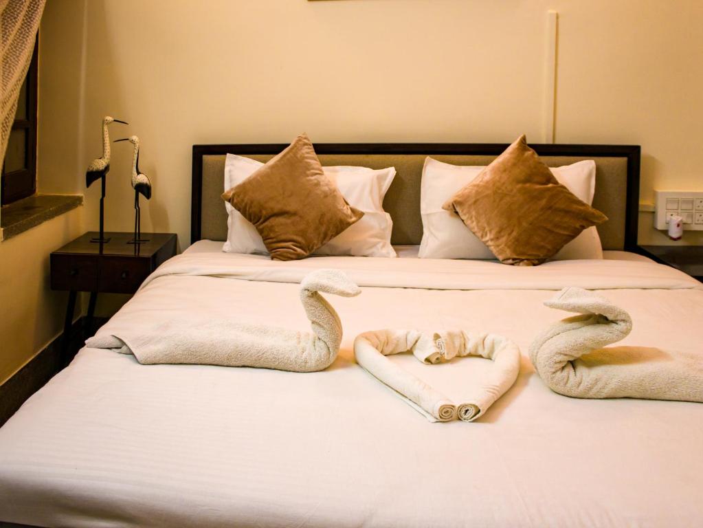 uma cama com dois cisnes feitos de toalhas em snooze inn jodhpur em Jodhpur