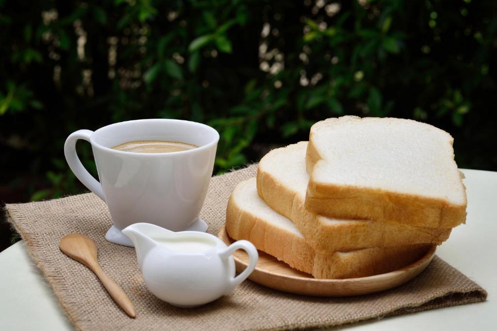 a plate of bread and a cup of coffee at Rovers Boys Hostel Dubai Near Gold Souq Metro in Dubai