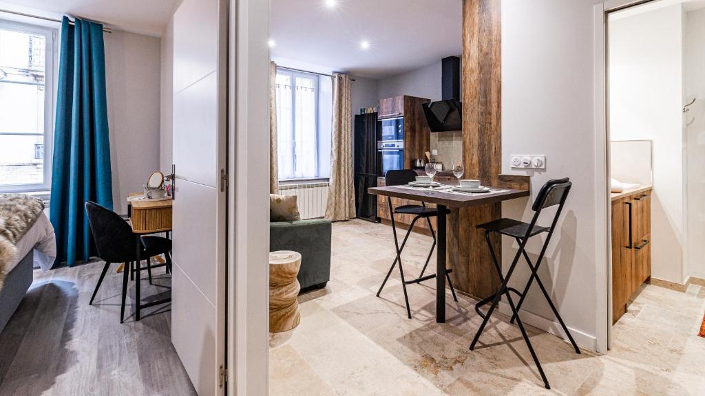 een klein appartement met een tafel en stoelen in een kamer bij Aux Fleurs de Darcy Confort Centre Ville in Dijon