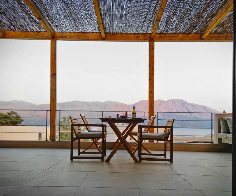 uma mesa e cadeiras com vista para o oceano em Villa Isa em Pogoniá