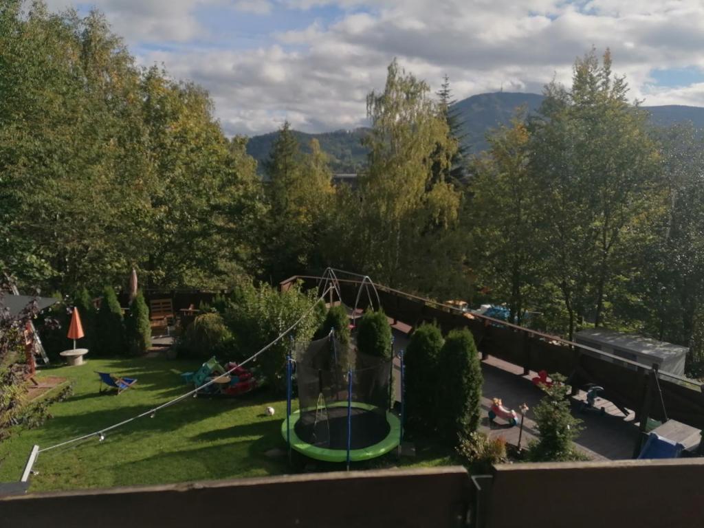 um parque infantil num jardim com um baloiço em Willa Na Górce em Szczyrk