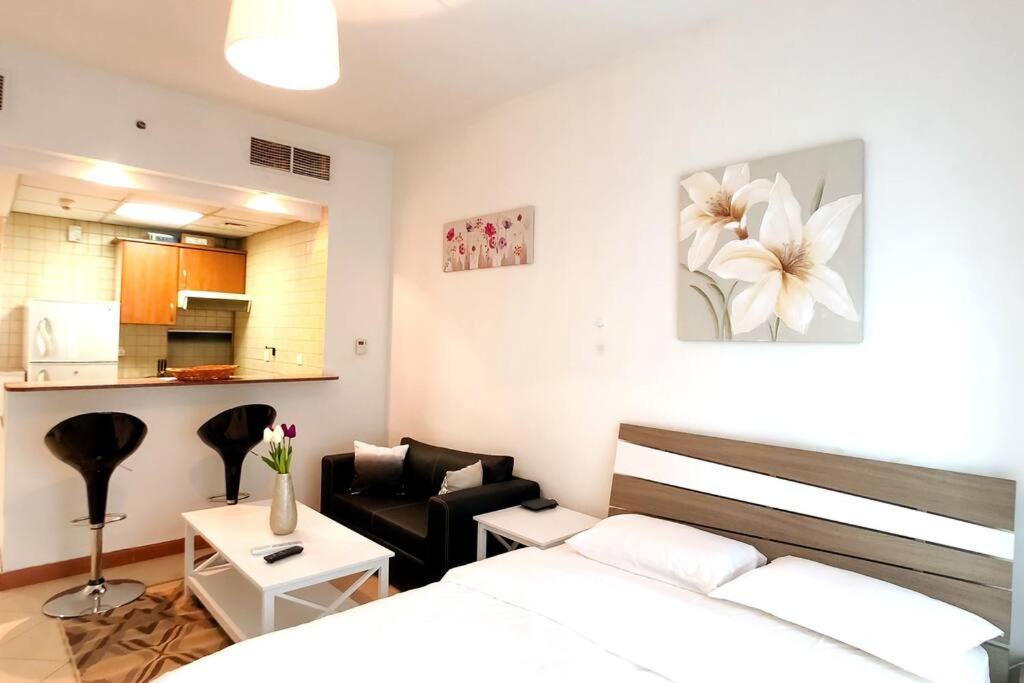 a bedroom with a bed and a living room at StoneTree - Prime Location - Furnished Studio - Near Metro in Dubai
