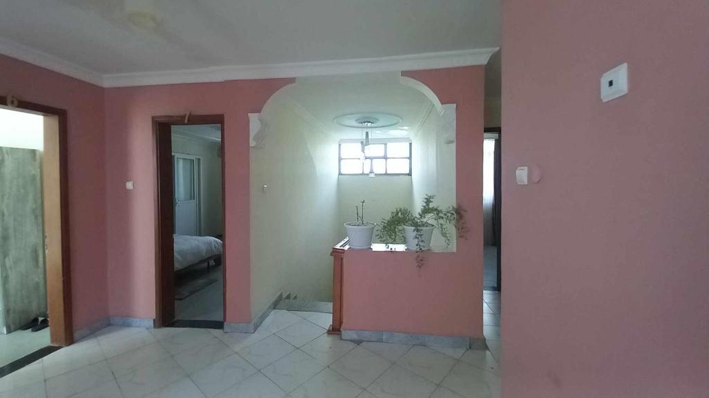 Pokój z różowymi ścianami i pokój ze stołem w obiekcie Zanzibar Guest House and Restaurant w Auasie
