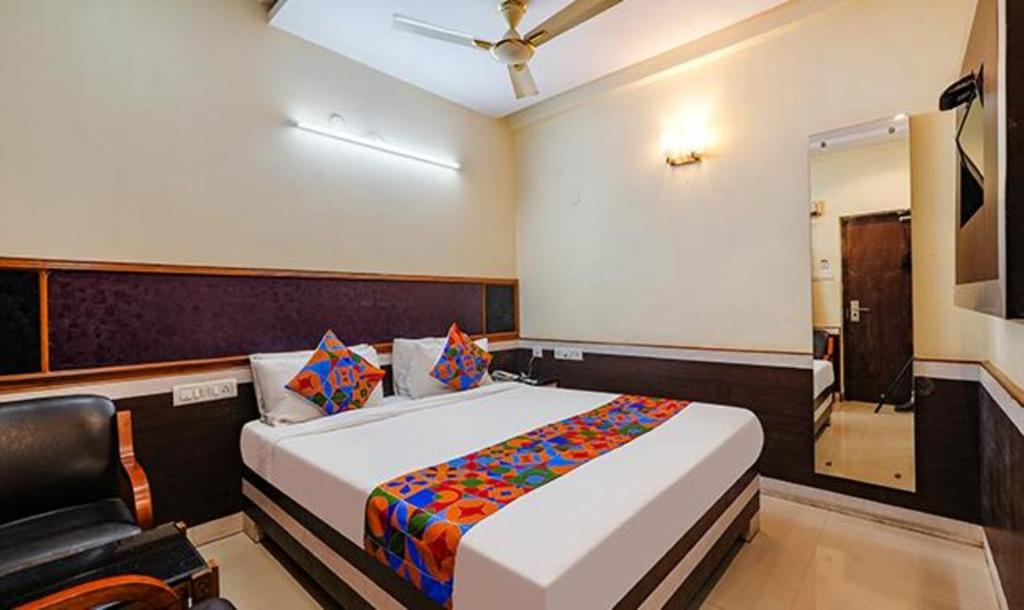1 dormitorio con 1 cama y 1 silla en FabHotel Sairam Residency, en Bangalore