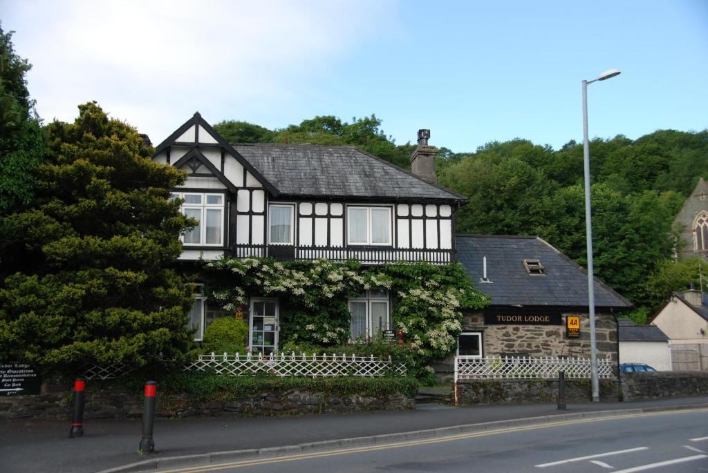 una casa en blanco y negro con flores. en Tudor Lodge, en Porthmadog