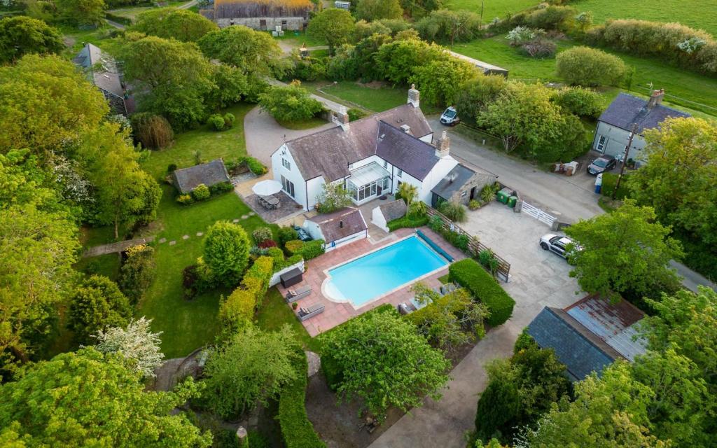 an aerial view of a house with a swimming pool at Country House with Heated Swimming Pool & Gardens in Rhiw