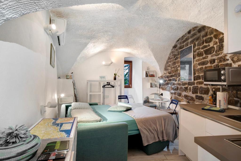 a small room with a bed in a kitchen at Grazioso open space in Sanremo
