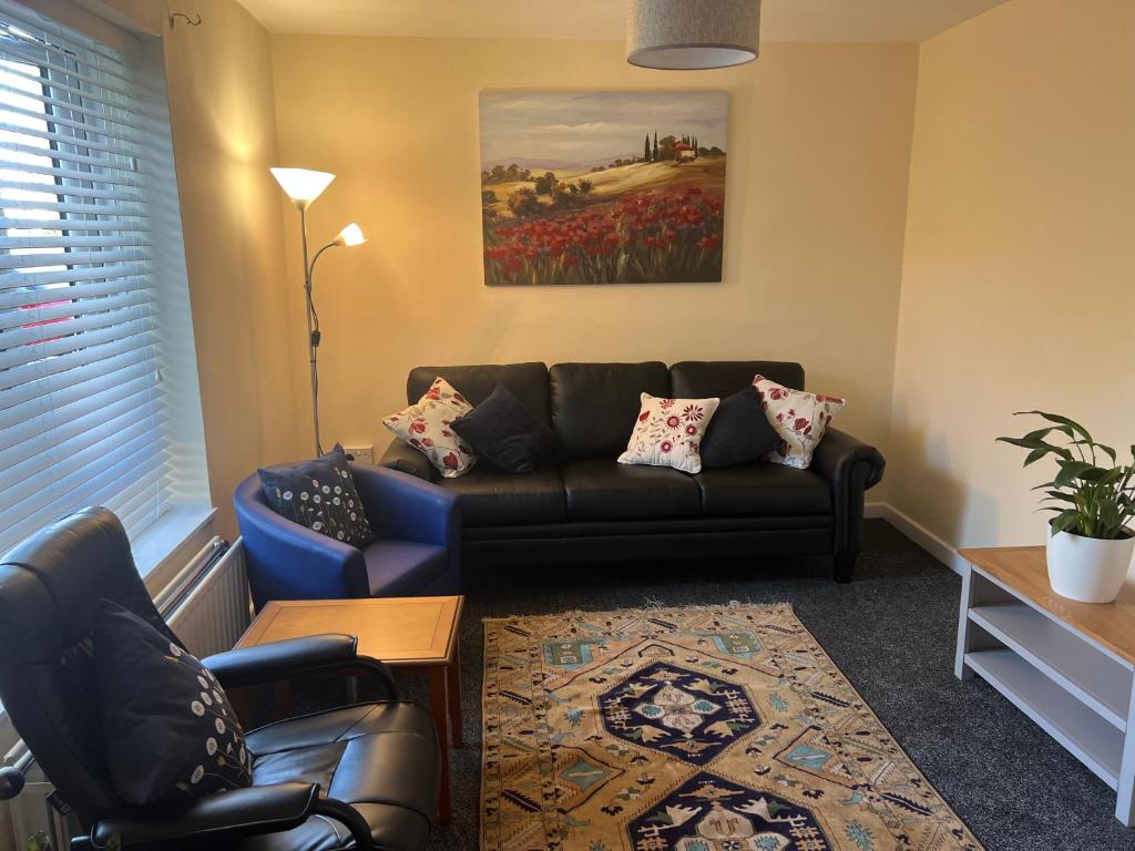 a living room with a couch and two chairs at NEW-4 Bdrm-6 quality beds-2 full bathrm-1 bath-3 vehicle forecourt-washer-dryer-Biz WiFi in Corby