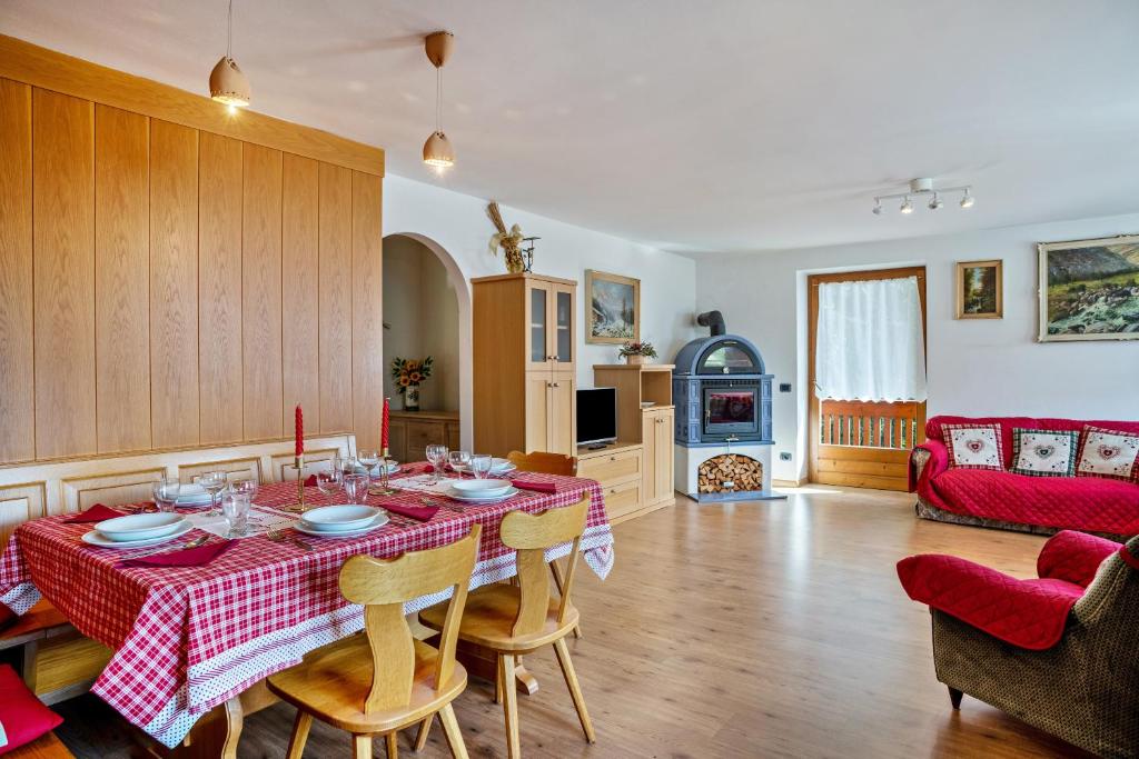 a kitchen and living room with a table and chairs at Casa Magda in Tesero