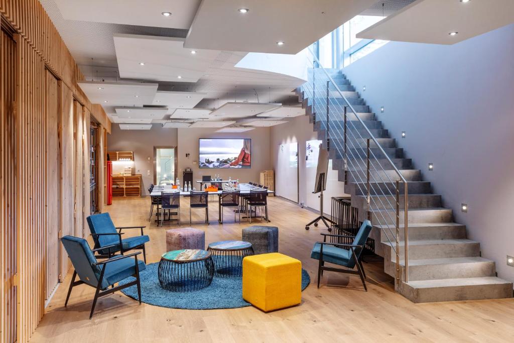 um átrio com uma escada, cadeiras e uma mesa em Sedartis Swiss Quality Hotel em Thalwil