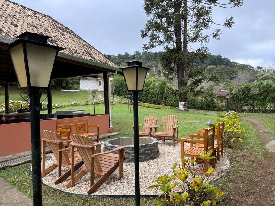 a group of chairs and a fire pit in a yard at Chácara Sakura in Santo Antônio do Pinhal
