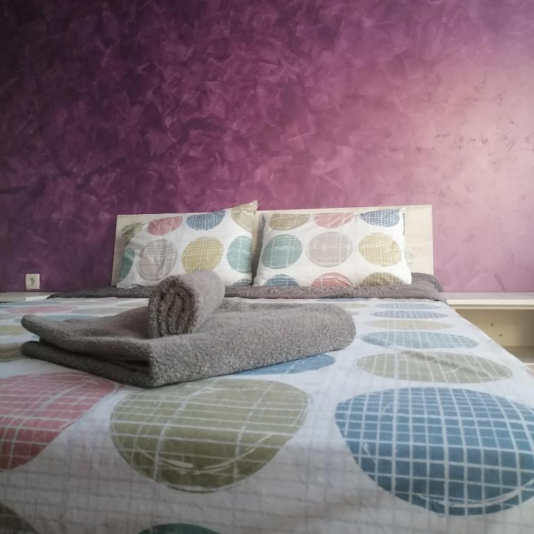 um quarto com uma cama com uma parede roxa em M Art Apart em Sófia