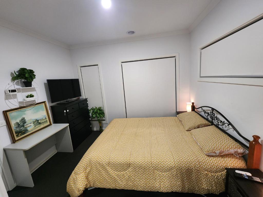 1 dormitorio con 1 cama y TV de pantalla plana en Private Ensuit in a Luxury Homestay en Caroline Springs