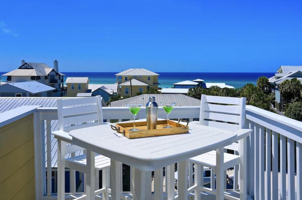 a white table with two glasses and two chairs on a balcony at Sea Prize at Grayton Beach in Santa Rosa Beach