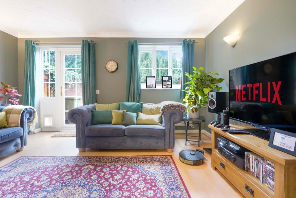 a living room with a couch and a television at Charming 4 Bedroom House in Prime Location - Close to City Centre - Free Parking, Smart TVs and Landscaped Garden by Yoko Property in Milton Keynes