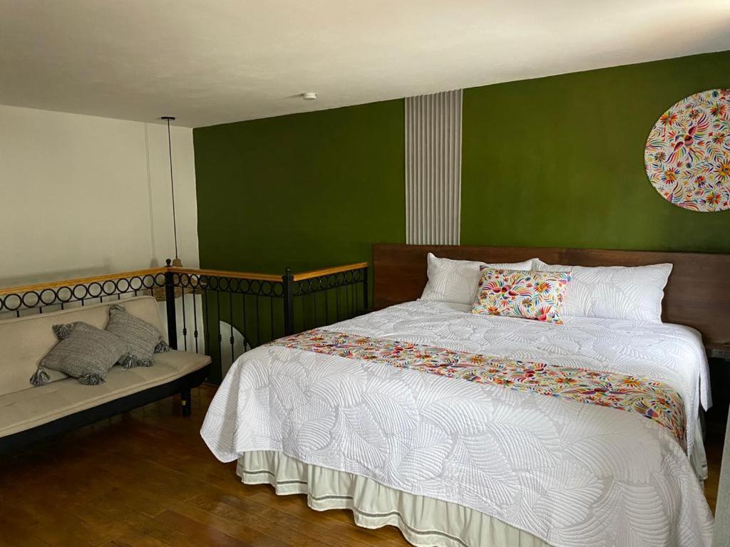 - une chambre avec un lit et un mur vert dans l'établissement PASEO REAL HOTEL BOUTIQUE, à Uruapan del Progreso