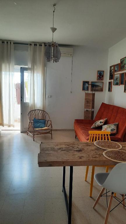 a living room with a red couch and a table at aychik homestay in Ariana