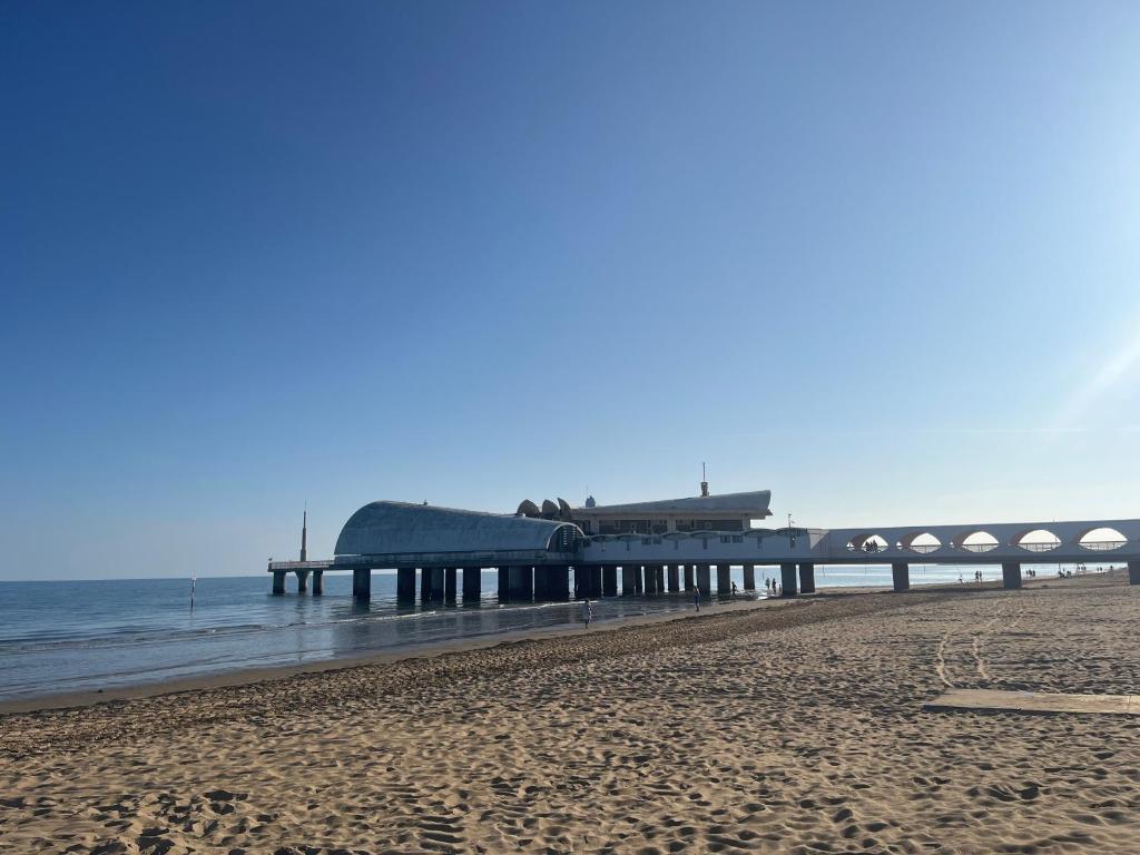 a pier on the beach next to the ocean at AppArt 24 city center parking and Sea in Lignano Sabbiadoro