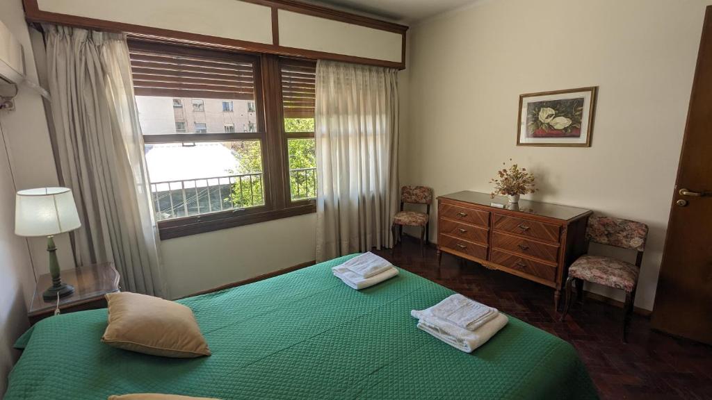 Un dormitorio con una cama verde y una ventana en Espejo Senior en Mendoza