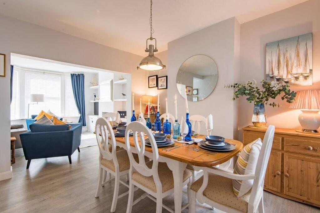 a dining room and living room with a table and chairs at Driftwood - Charming family home in Deal