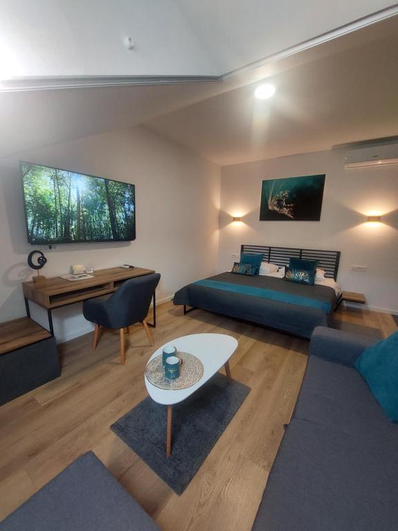 ein Wohnzimmer mit einem Bett und einem Tisch in der Unterkunft COMFORT Suites VELIKA GORICA in Velika Gorica