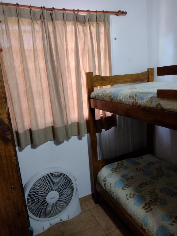 a room with two bunk beds and a fan at Departamento "Juana"para 4 personas 2 cuartos con garage en Santa Teresita in Santa Teresita