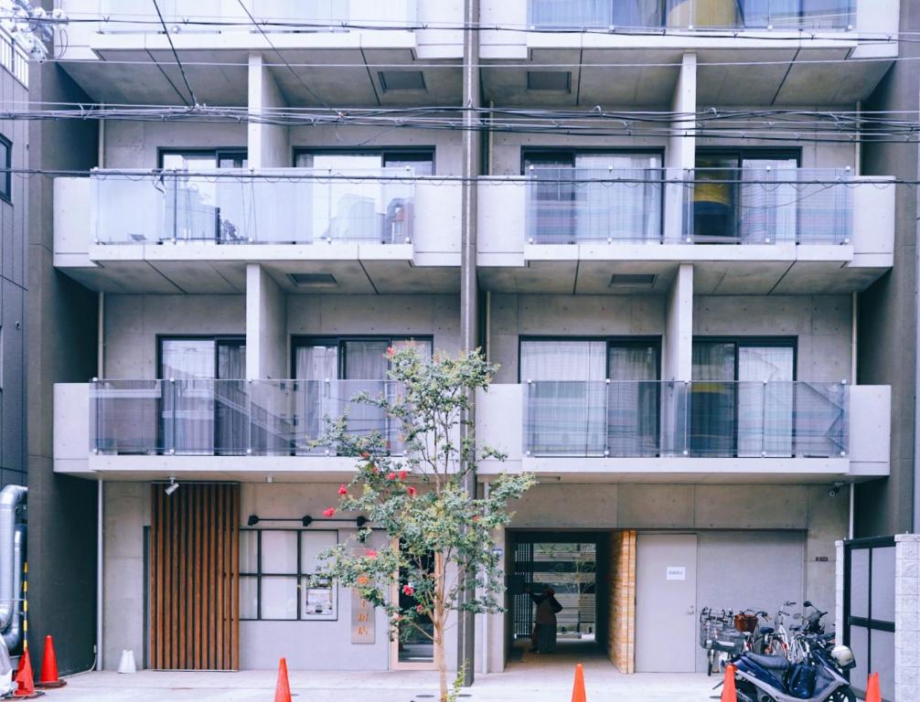 a building with balconies and a tree in front of it at REST COLLECTION Kujo Osaka in Osaka