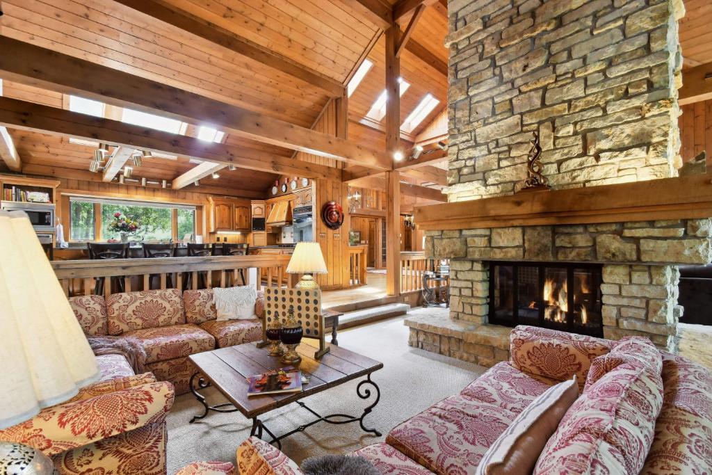 a living room with couches and a stone fireplace at Galena Getaway with Hot Tub, Home Theater and More! in Galena