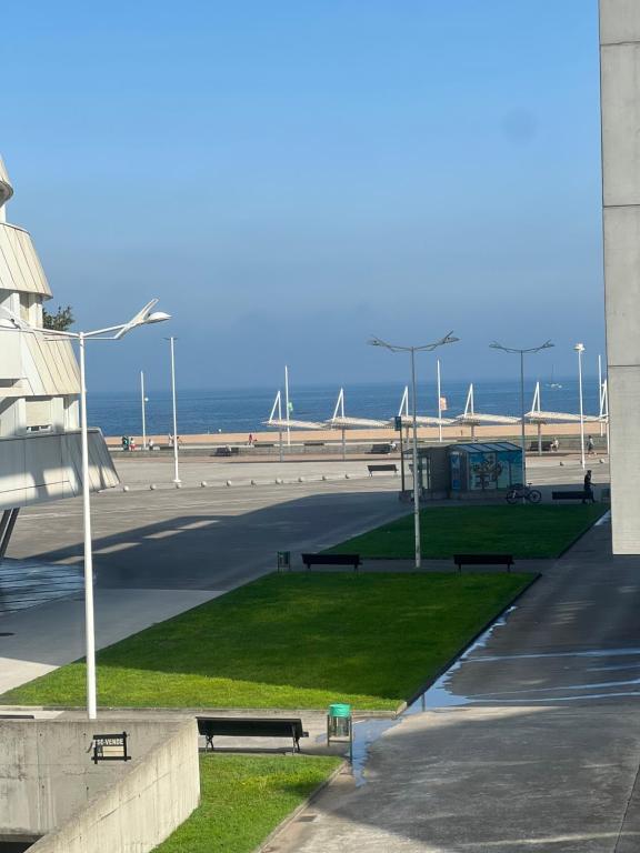 een park met banken en de oceaan op de achtergrond bij Primera línea playa con parking in Gijón