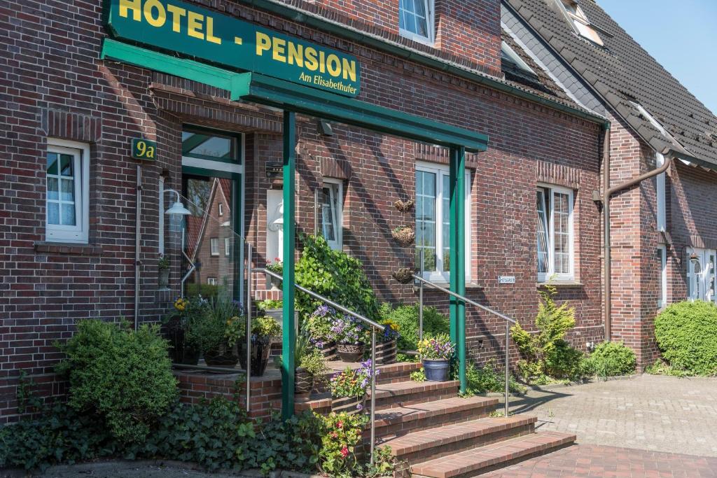 a hotel with a sign on the front of a brick building at Hotel am Elisabethufer in Jever