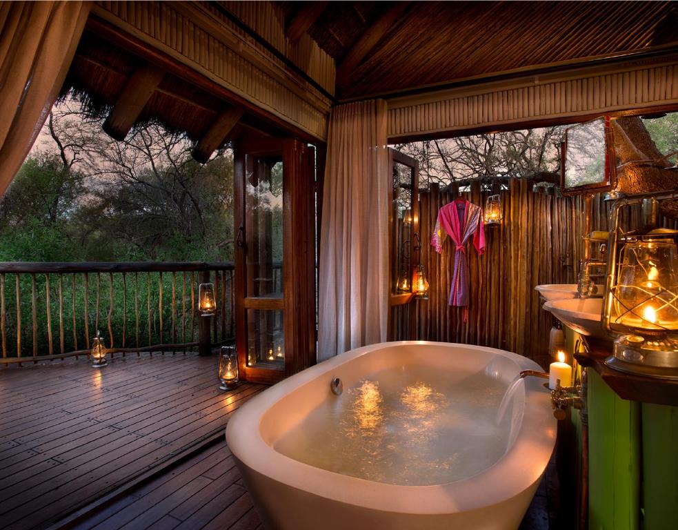 a bathroom with a bath tub on a wooden deck at Jaci's Lodges in Madikwe Game Reserve
